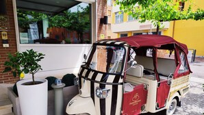 A vintage three-wheeled vehicle parked outside a building with a sign reading "Hotel Benaco." - Benaco (Garda)