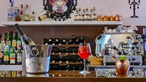 A bar area with a variety of liquor bottles, a cocktail shaker, and a wine rack in the background. - Benaco (Garda)