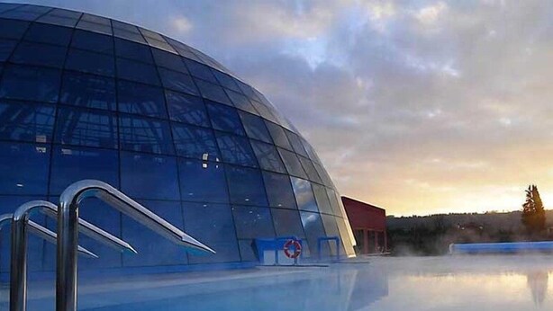 A modern building with a glass facade and a reflective pool in front. - Benaco (Garda)