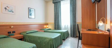 A hotel room with two single beds, a desk, a chair, a television, and a window with curtains.