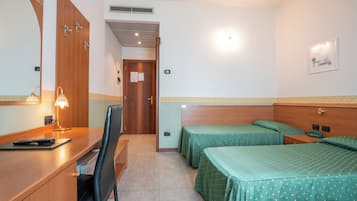 Una camera d'albergo con una scrivania, due letti singoli, una sedia e uno specchio.