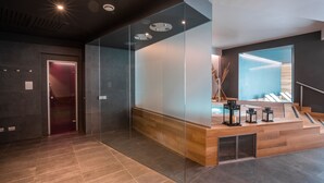 A modern lobby with a glass partition, a reception desk, and a staircase.