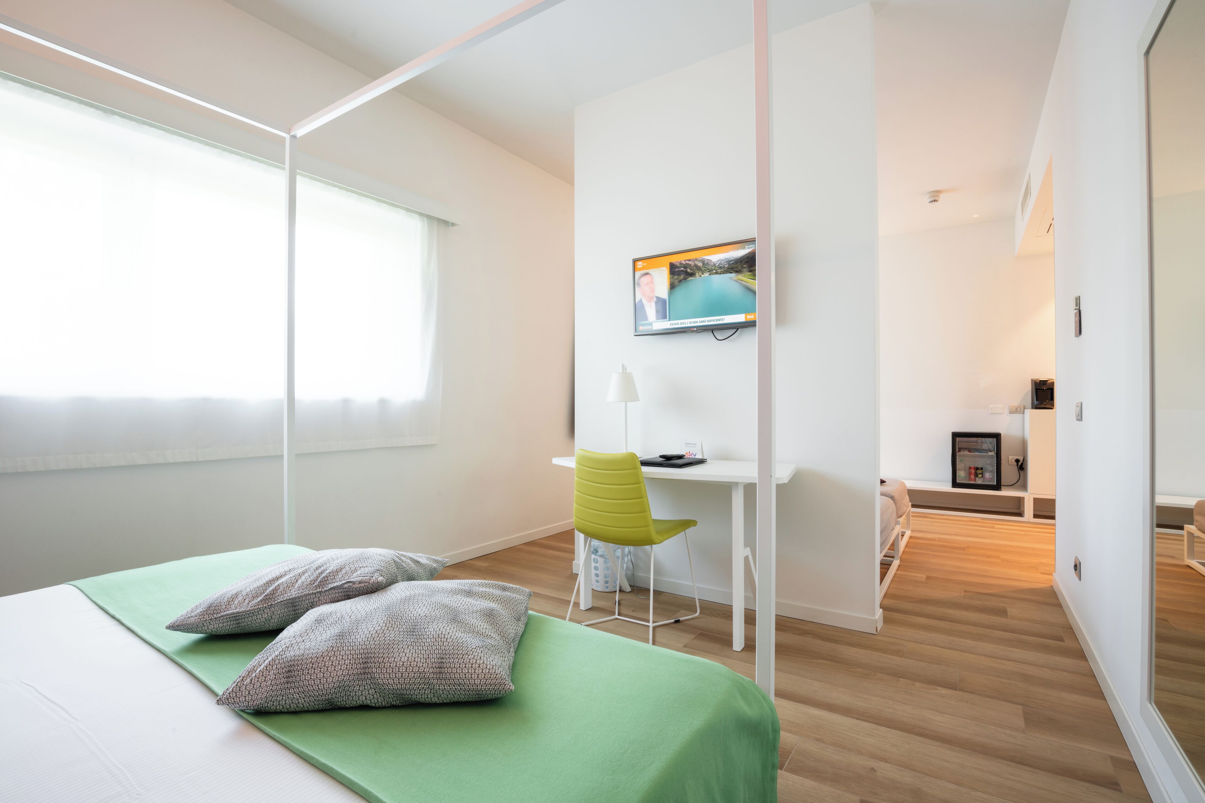Una habitación de hotel moderna con cama, escritorio y silla.