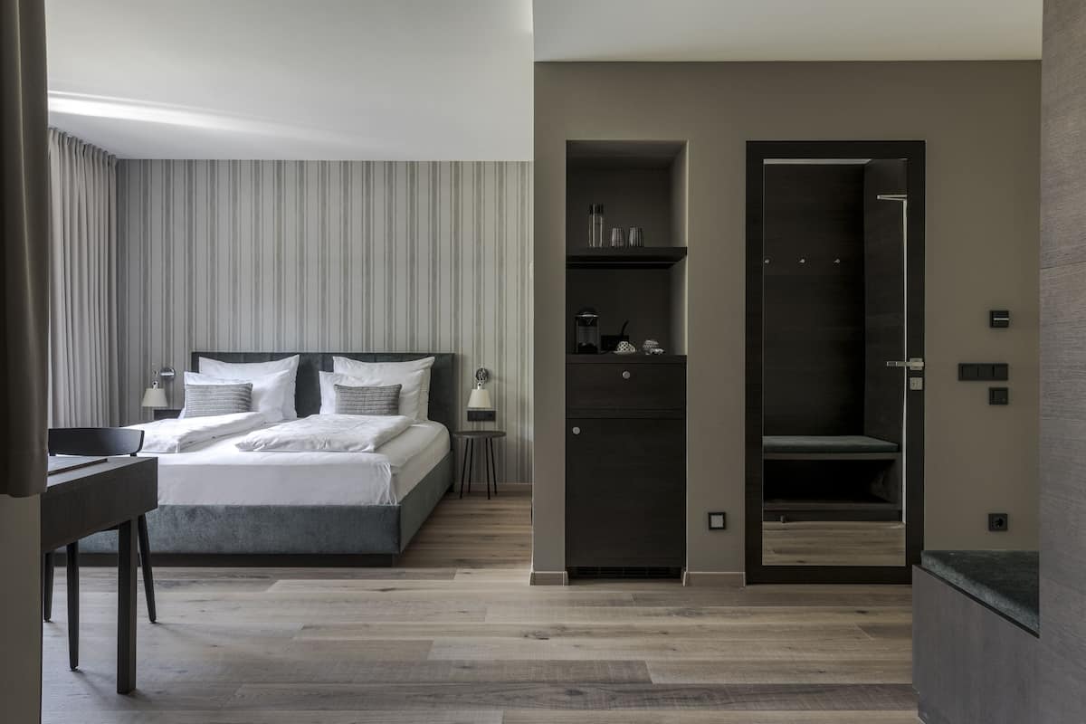 Junior suite, uitzicht op tuin | Luxe beddengoed, een minibar, een kluis op de kamer, een bureau