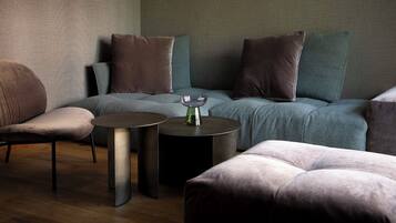 A modern lounge area with a sofa, two side tables, and a decorative vase.