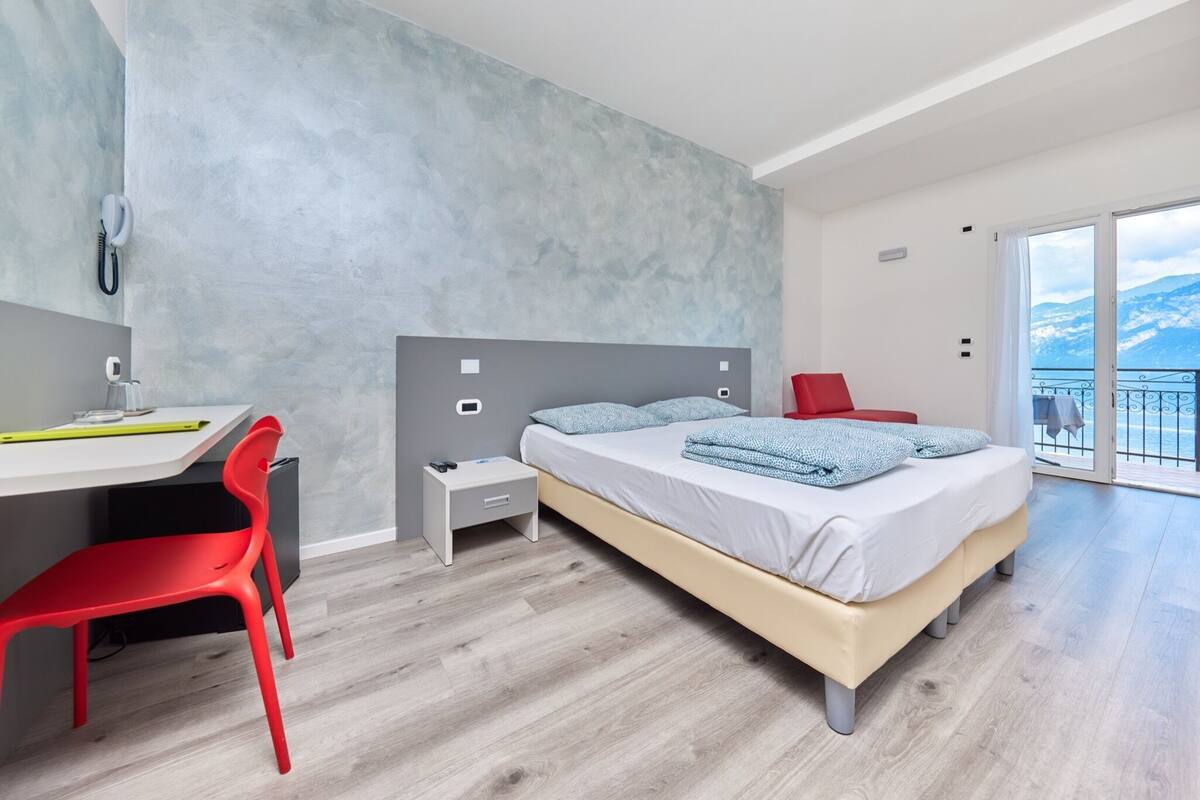Un dormitorio moderno con una cama grande, un escritorio y una silla.