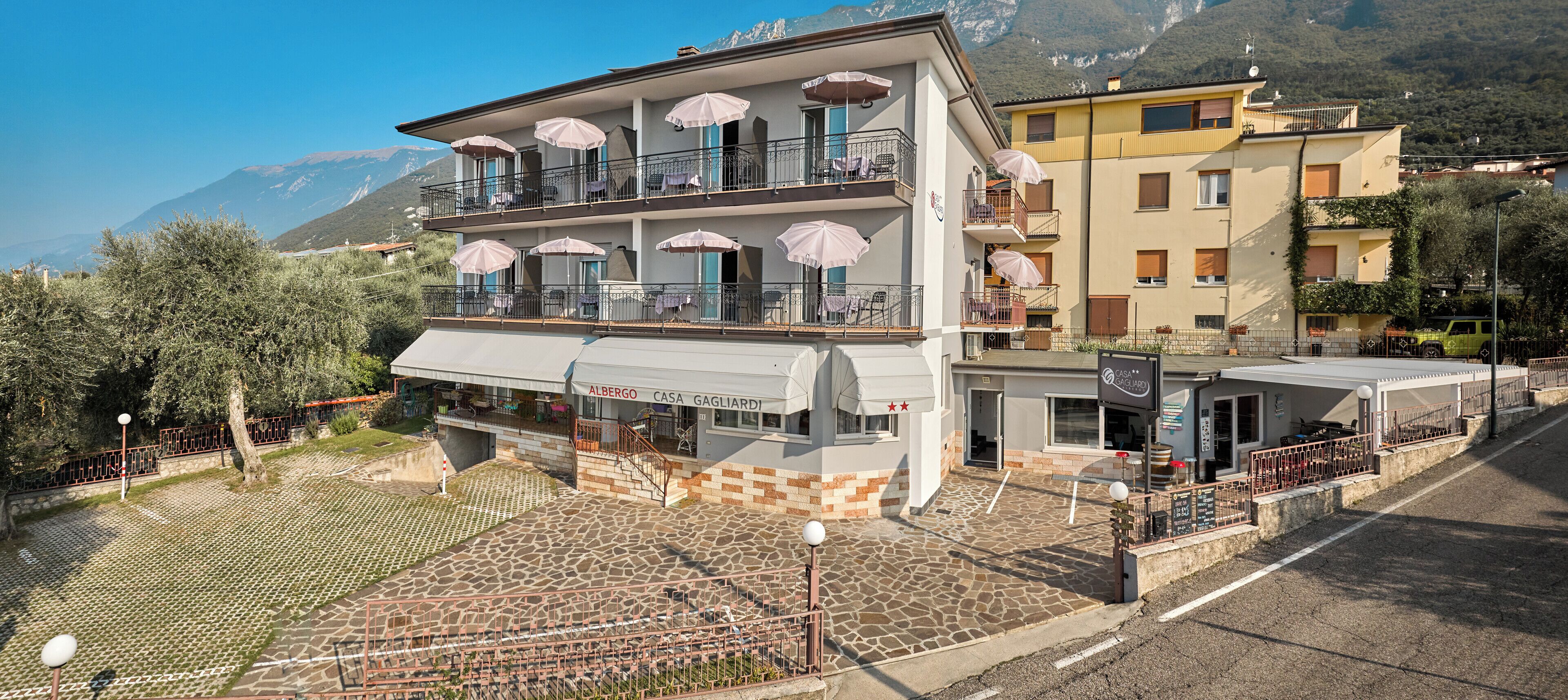 Un hotel con terraza, mobiliario exterior y vistas a la montaña.