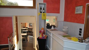 Een hotel receptie met een balie, een prullenbak en een bord dat de uitgang aangeeft.