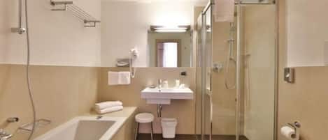 Un baño moderno con bañera, lavamanos y ducha envuelta en vidrio.