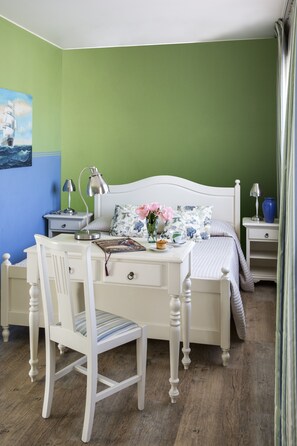 Une chambre à coucher avec un lit, des tables de chevet, un bureau et une chaise.