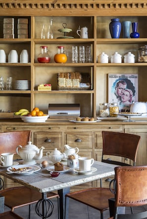 Une cuisine avec des meubles de rangement en bois, une table à manger avec des chaises, ainsi que divers ustensiles et accessoires de cuisine.