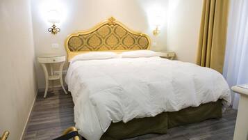 Una habitación de hotel con una cama grande, dos mesitas de noche y una silla.