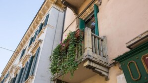 A building with a balcony with green shutters and a small window. - Hotel al Castello (Verona)