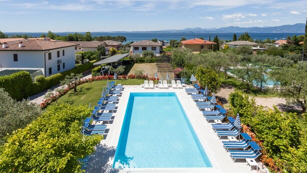 Une piscine avec des chaises longues et vue sur la mer.