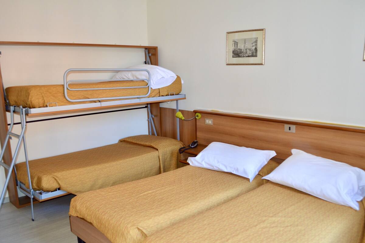 Un dormitorio con literas y dos camas individuales.