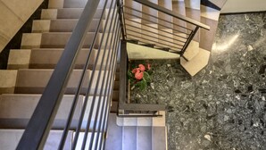 Una escalera moderna con barandilla de metal y un pequeño arreglo floral en la parte inferior.
