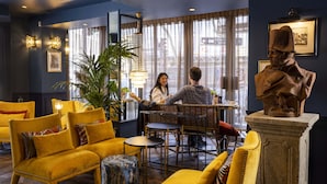 Un intérieur chaleureux avec des canapés jaunes, un coin repas et une statue.