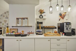 A breakfast bar with a toaster, bread, and a coffee machine. -  La Parizienne (Paris)