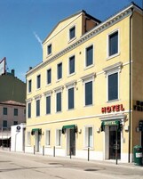 Un edificio giallo con un cartello che riporta la scritta 'HOTEL' sulla facciata.
