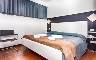 Una camera da letto moderna con un letto, una sedia e un comodino.
