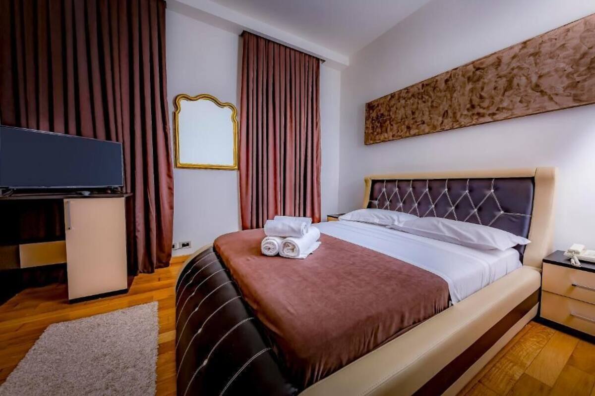 Una habitación de hotel con cama, televisión, escritorio y espejo.