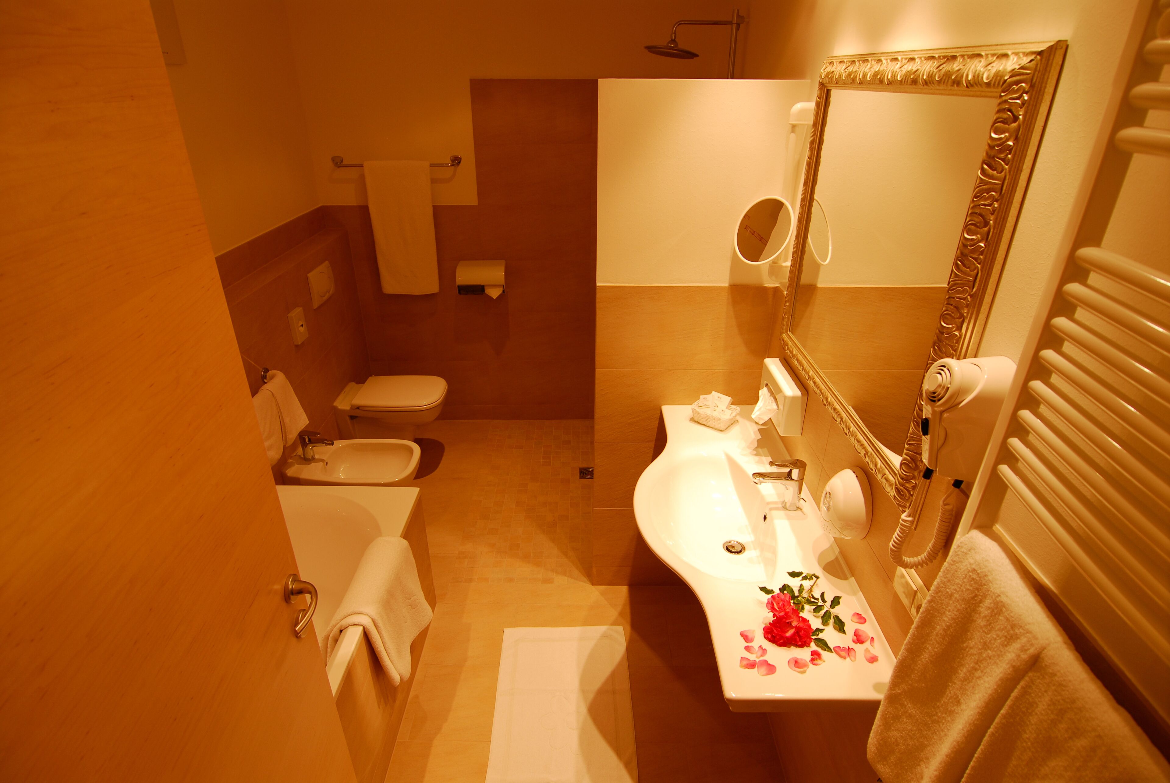 Un baño con inodoro, lavamanos y espejo.