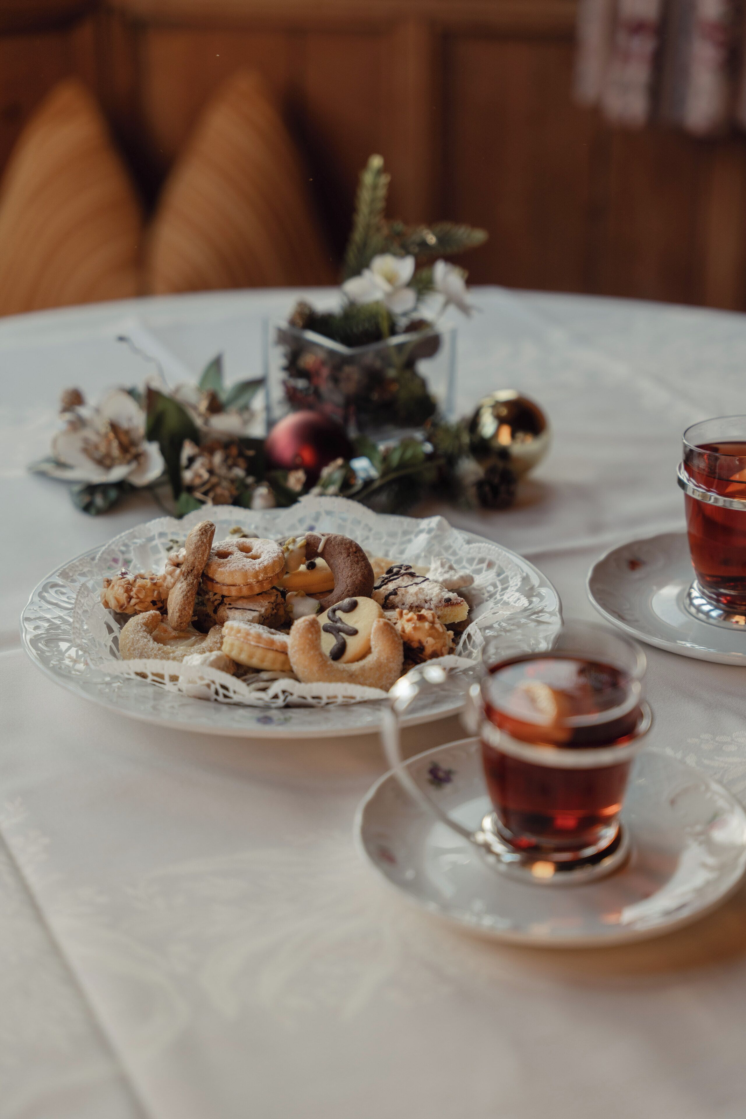 A table with a plate of cookies and a glass of tea.