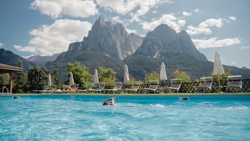 Una piscina techada, una piscina al aire libre de temporada, sombrillas