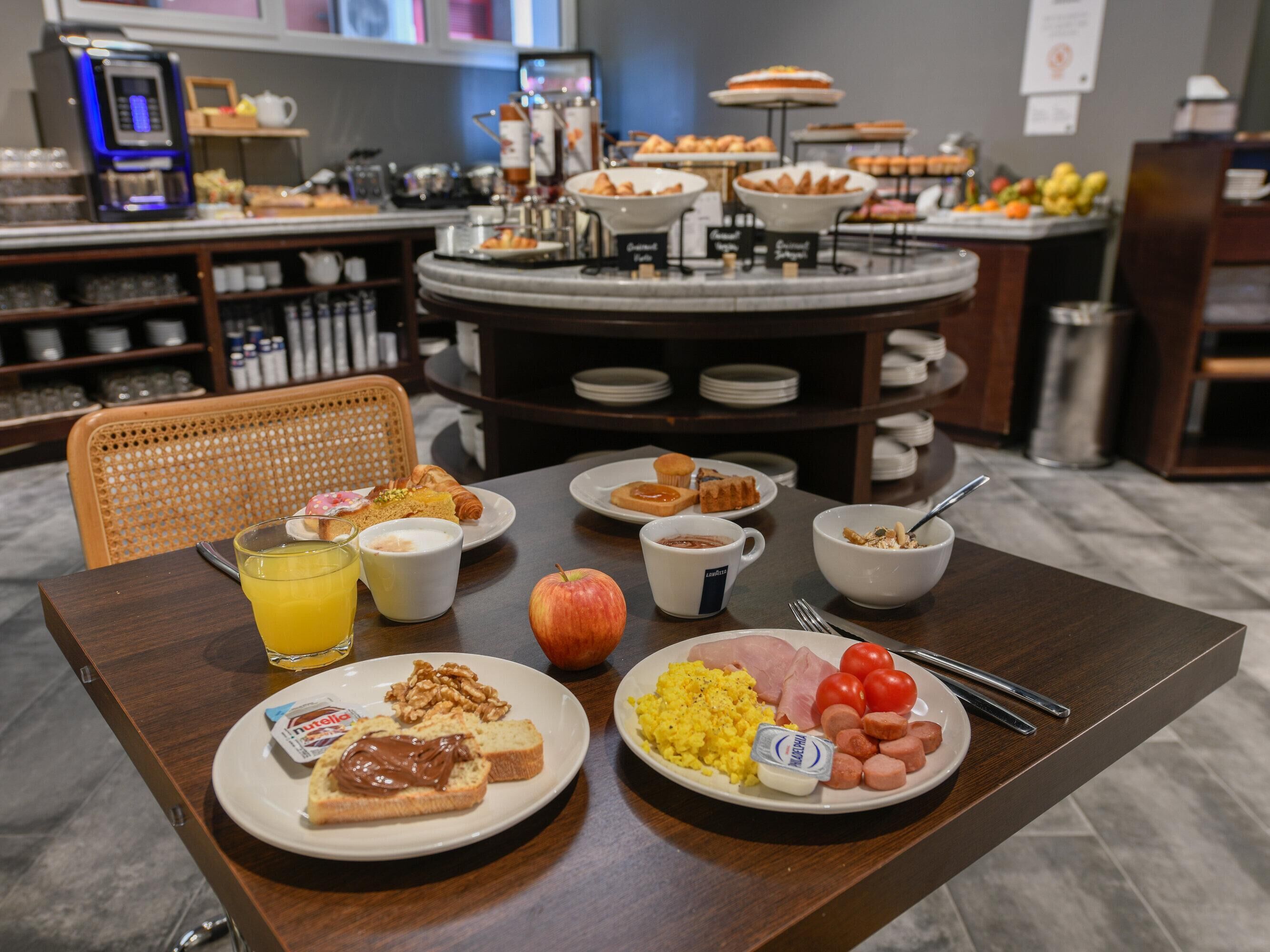 A breakfast buffet with various food items and a coffee station.
