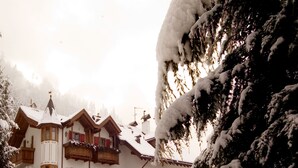 Un edificio cubierto de nieve con un estilo arquitectónico tradicional, que cuenta con balcones y una entrada central.