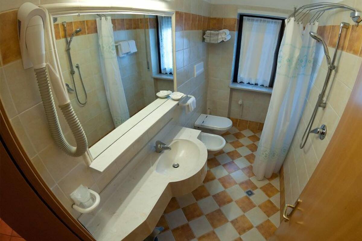 A bathroom with a sink, toilet, and shower.