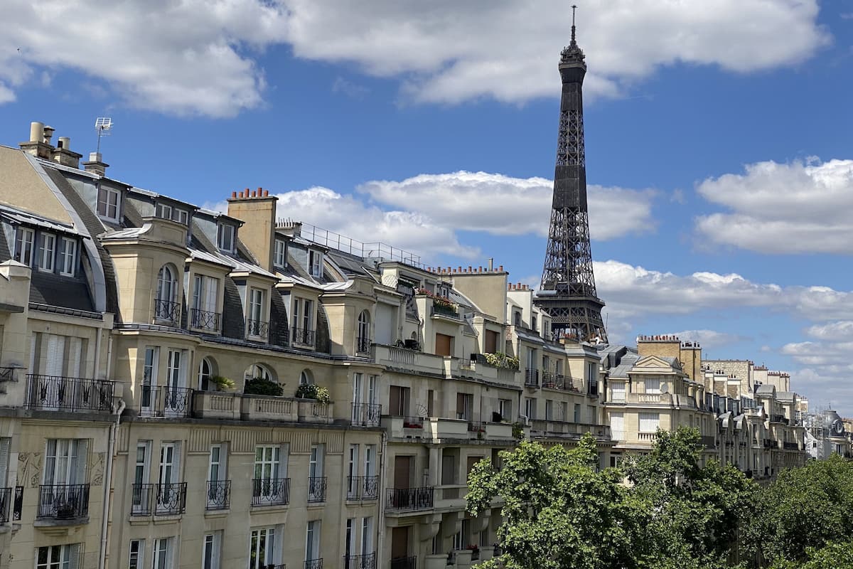 A view of the Eiffel Tower with surrounding Parisian buildings.