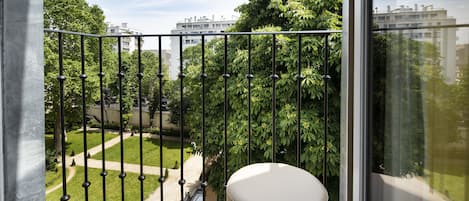 A balcony with a view of a park and buildings.
