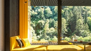A room with a wooden bench and a table with a glass container and a candle. - Prinz Rudolf Smarthotel (Merano)