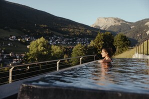 Een buitenzwembad, parasols bij het zwembad en ligstoelen