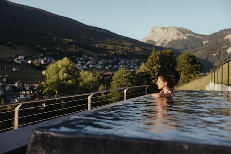 Una piscina al aire libre, sombrillas, sillones reclinables de piscina