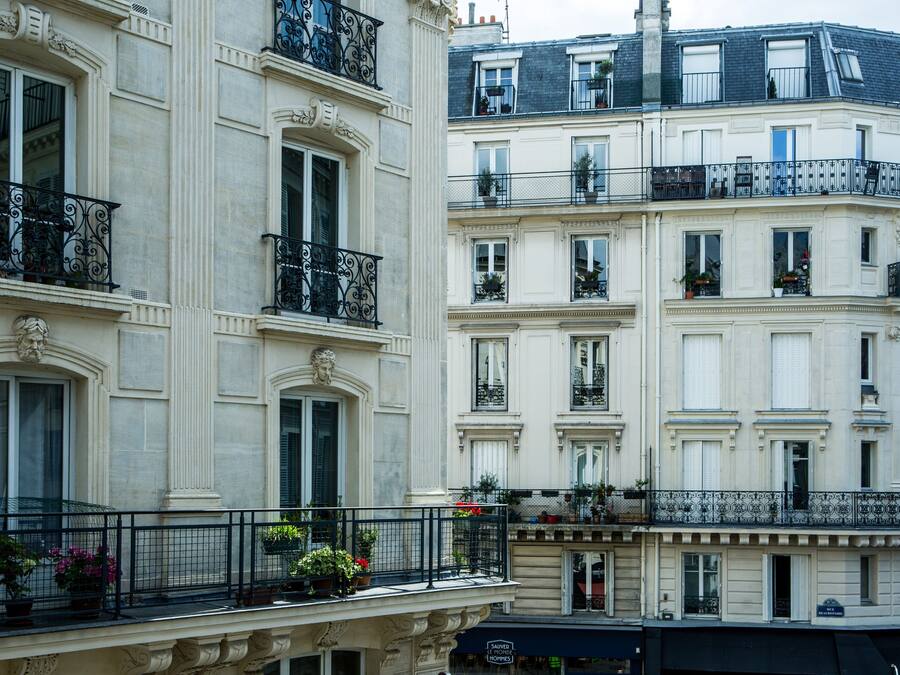 Un edificio de varios pisos con balcones, ventanas amplias y detalles arquitectónicos decorativos.