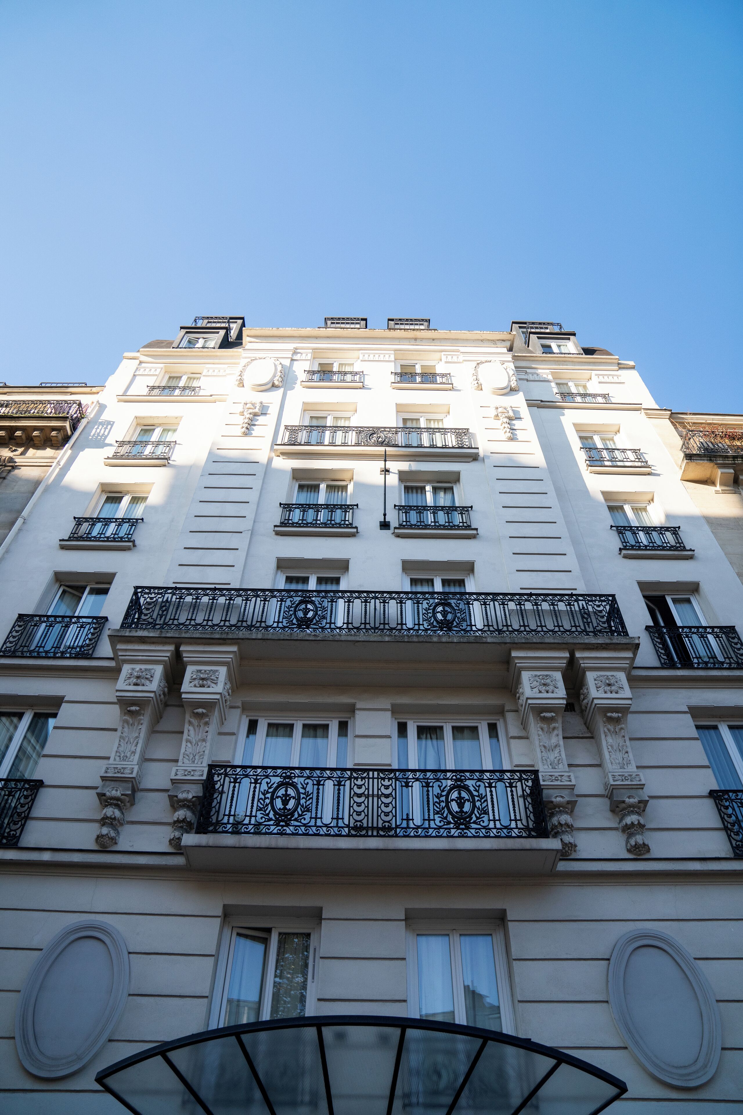 A multi-story building with balconies, large windows, and classical architectural details.