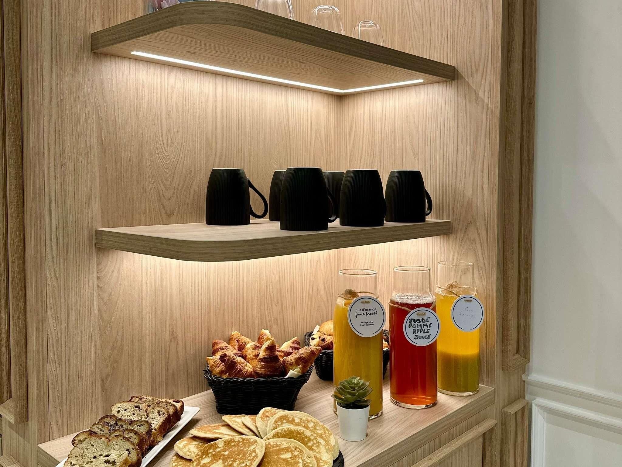 A breakfast buffet with croissants, bread, and juice options.