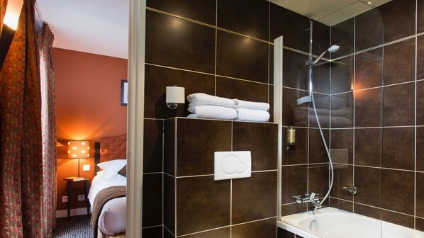Un baño moderno con ducha, lavamanos y toallero.