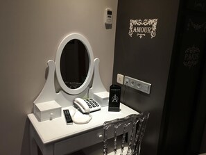 A hotel room vanity with a mirror, telephone, and a Grand Hotel emblem. - Grand Hôtel Amelot (Paris)