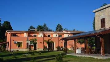 A two-story building with a flat roof and a covered patio area.