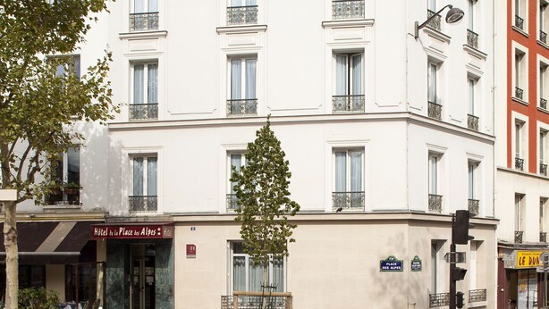 A multi-story hotel with a classic European architectural style, featuring balconies, large windows, and a prominent hotel sign. - Hôtel de la Place des Alpes (Paris)