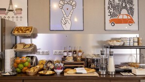 A breakfast buffet with various food items, a basket of croissants, and a wall with art depicting Paris landmarks.
