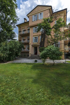A multi-story building with a symmetrical facade, balconies with railings, and a central entrance with steps. - Hotel Elephant (Bressanone)