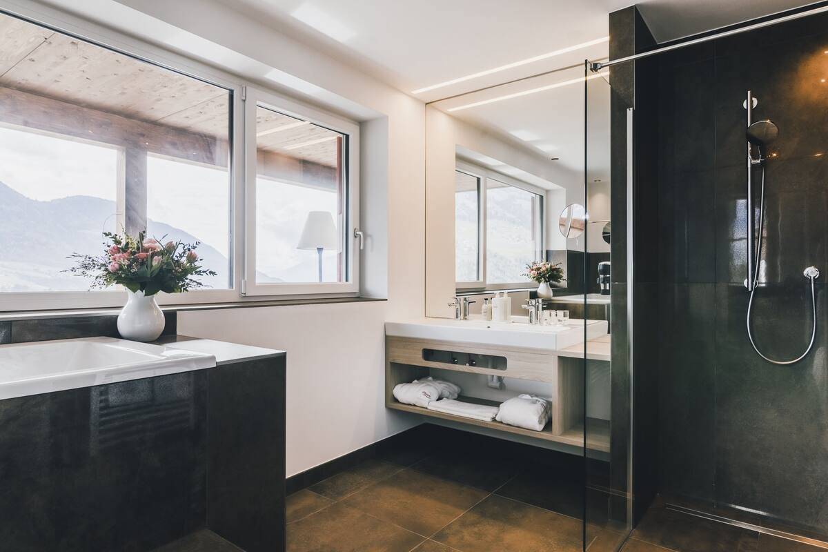 deluxe suite | bathroom | eco-friendly toiletries, hair dryer, bathrobes, slippers