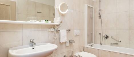 A modern bathroom with a sink, bidet, toilet, and a shower area.