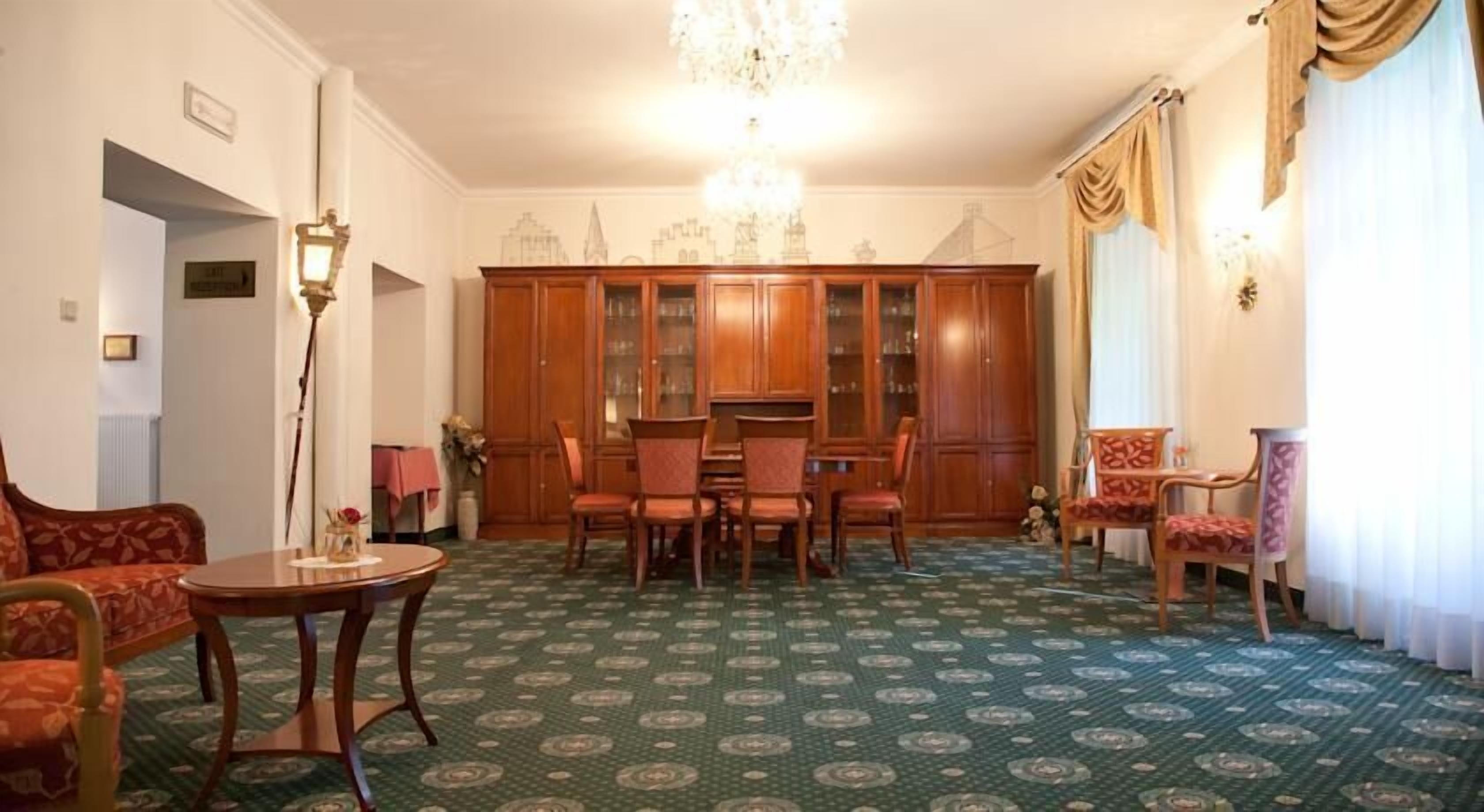 Een klassieke kamer met een kamerbreed tapijt, houten meubels en een kroonluchter.
