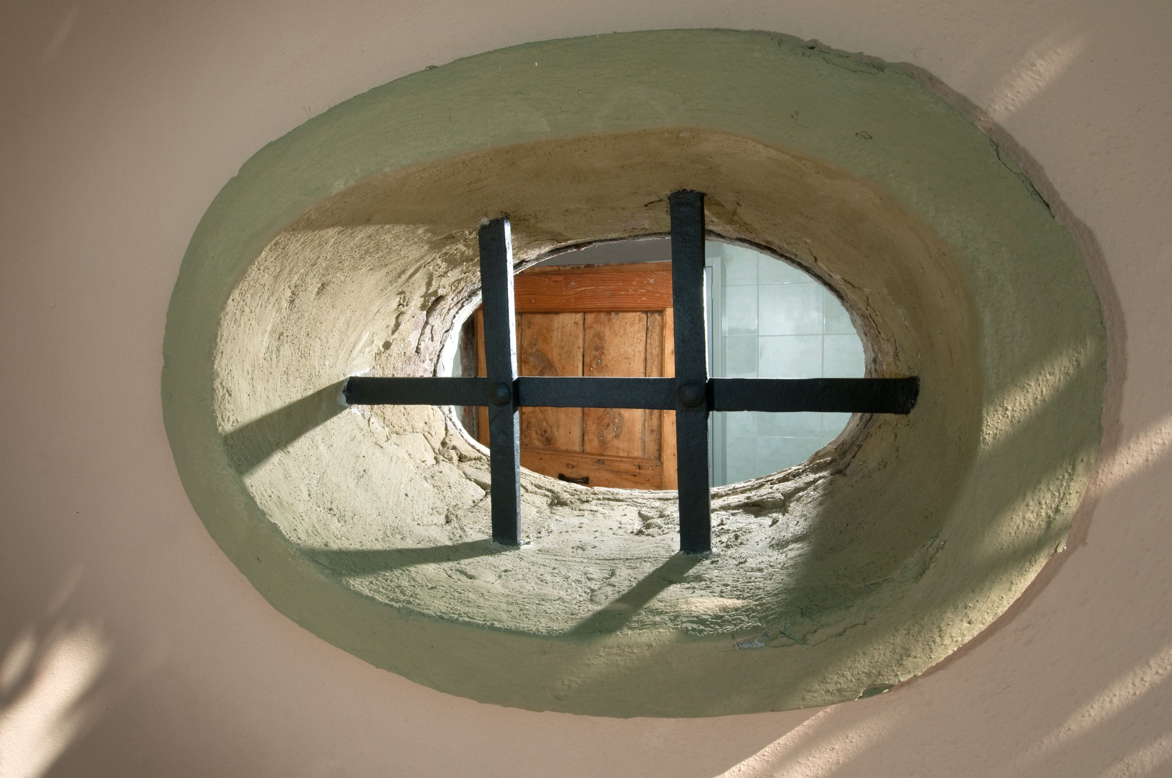 A circular skylight with a wooden door and black crossbars.
