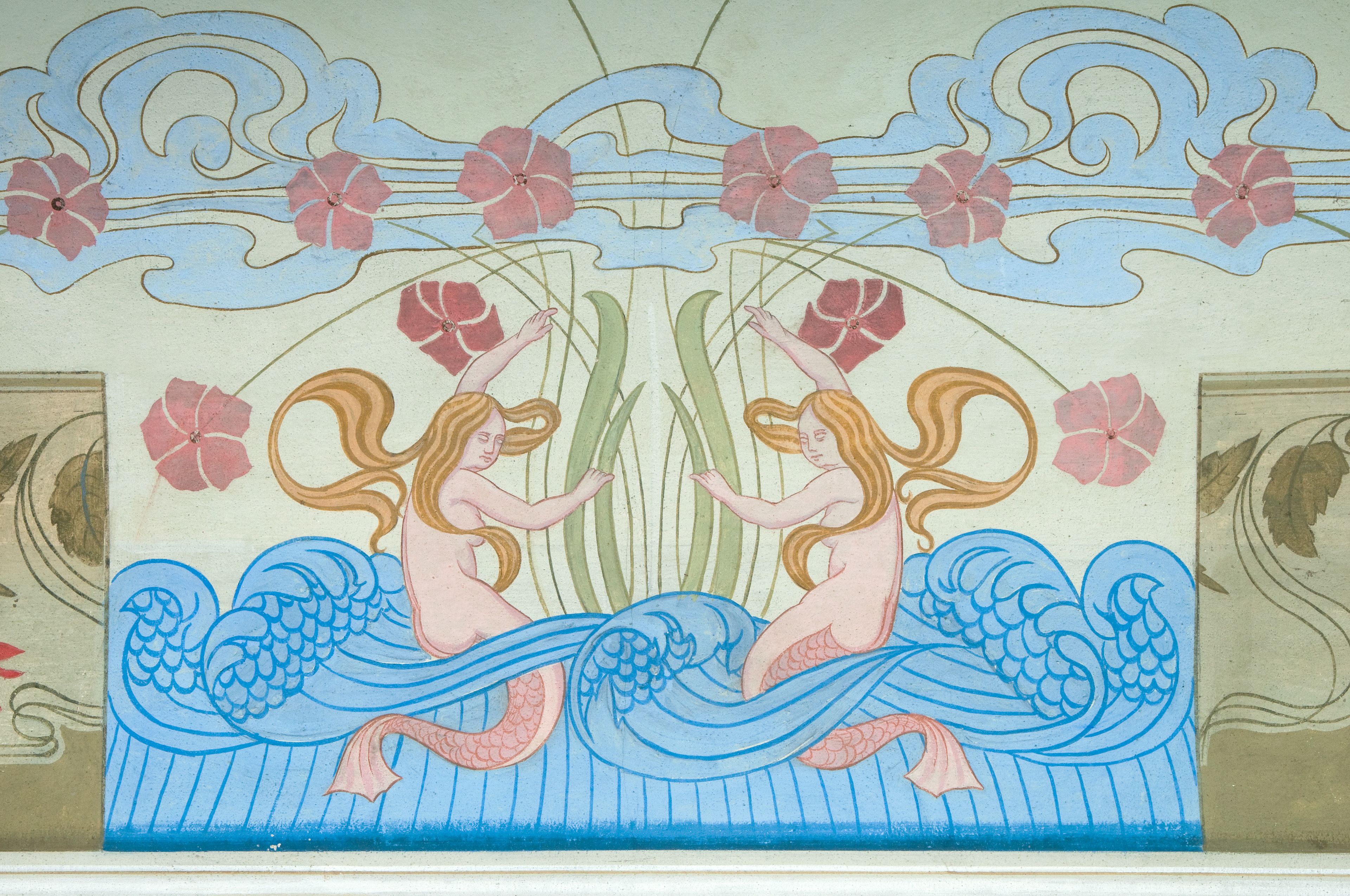Un mural con dos figuras en un entorno acuático estilizado, con motivos florales y de olas.